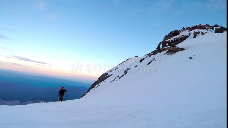 Άτομο που αναρριχείται επάνω στο χιονώδη τσεκούρι και τα σκυλιά έλκηθρου πάγου βουνών