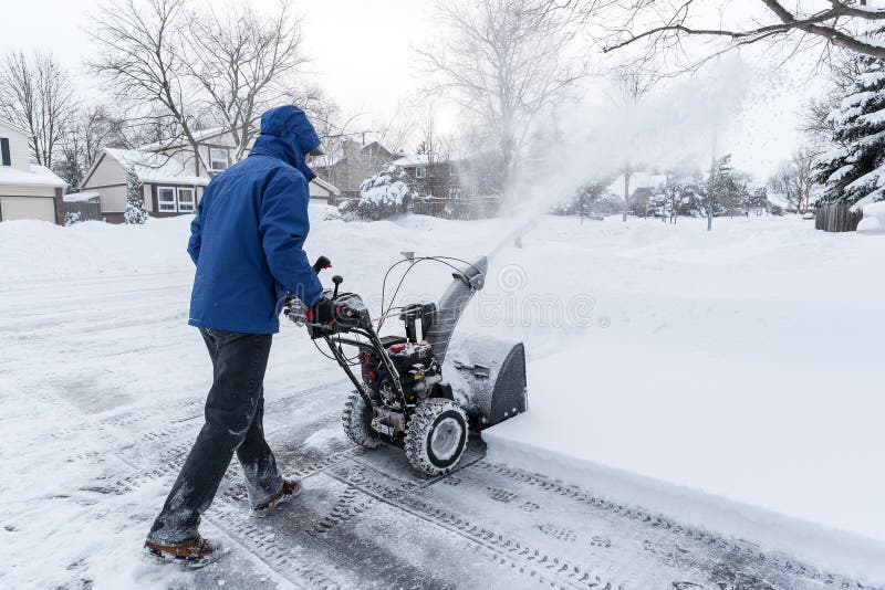 Man clearing snow with a gas snow blower in a suburb #1. Man clearing snow with a gas snow blower in a suburb #1