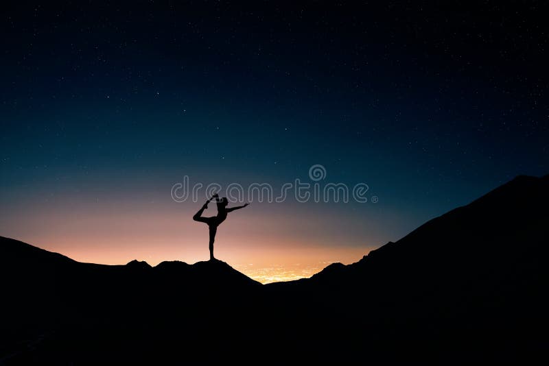 Fit Man in silhouette doing yoga natarajasana pose at night city and starry sky background. Fit Man in silhouette doing yoga natarajasana pose at night city and starry sky background