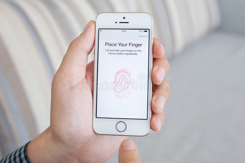 Άτομο που κρατά ένα άσπρο iPhone 5s με την ταυτότητα αφής στην οθόνη στοκ φωτογραφίες με δικαίωμα ελεύθερης χρήσης Άτομο που κρατά ένα άσπρο iPhone 5s με την ταυτότητα αφής στην οθόνη στοκ φωτογραφίες με δικαίωμα ελεύθερης χρήσης