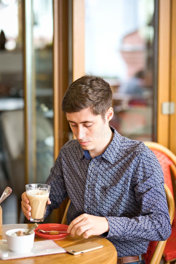 Άτομο που πίνει το μεγάλο latte σε έναν πίνακα καφέδων στοκ εικόνες με δικαίωμα ελεύθερης χρήσης Άτομο που πίνει το μεγάλο latte σε έναν πίνακα καφέδων στοκ εικόνες με δικαίωμα ελεύθερης χρήσης