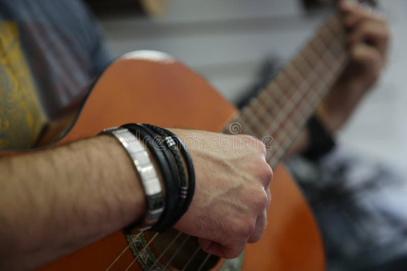 Άτομο που παίζει μια κλασική κιθάρα Μαζεύει με το χέρι επάνω τις σειρές στην κιθάρα στοκ εικόνα Άτομο που παίζει μια κλασική κιθάρα Μαζεύει με το χέρι επάνω τις σειρές στην κιθάρα στοκ εικόνα