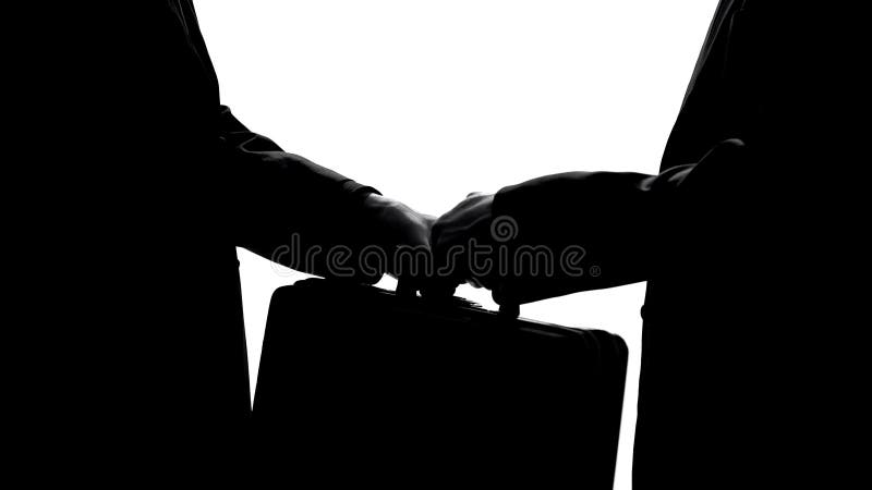 Άτομο που περνά τη βαλίτσα στο συνεργάτη, την επιχειρησιακή συμφωνία ή την οικονομική έννοια απάτης στοκ εικόνες Άτομο που περνά τη βαλίτσα στο συνεργάτη, την επιχειρησιακή συμφωνία ή την οικονομική έννοια απάτης στοκ εικόνες