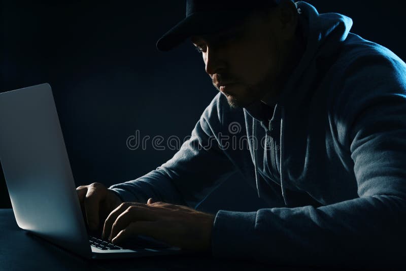 Άτομο που χρησιμοποιεί το lap-top στον πίνακα στο σκοτάδι Ποινική δραστηριότητα στοκ φωτογραφίες Άτομο που χρησιμοποιεί το lap-top στον πίνακα στο σκοτάδι Ποινική δραστηριότητα στοκ φωτογραφίες