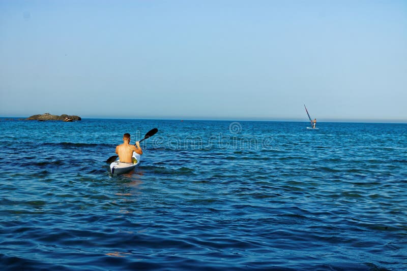 Άτομο σε ένα κανό στη θάλασσα, Kayaking, κωπηλασία σε κανό στοκ εικόνα Άτομο σε ένα κανό στη θάλασσα, Kayaking, κωπηλασία σε κανό στοκ εικόνα