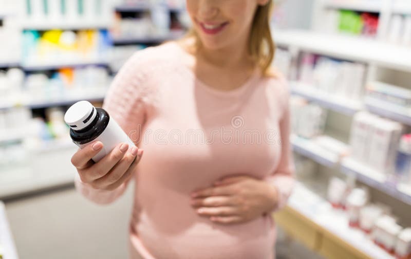 Έγκυος γυναίκα που επιλέγει την ιατρική στο φαρμακείο στοκ φωτογραφία με δικαίωμα ελεύθερης χρήσης Έγκυος γυναίκα που επιλέγει την ιατρική στο φαρμακείο στοκ φωτογραφία με δικαίωμα ελεύθερης χρήσης