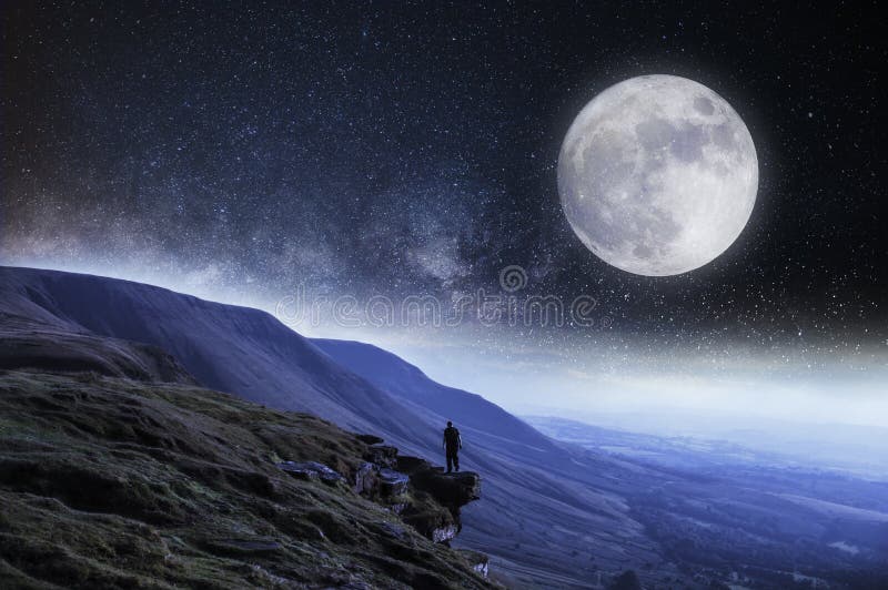 Ένα nightime εκδίδει Ένας οδοιπόρος στην άκρη ενός απότομου βράχου που περιβάλλεται από τα βουνά με το φεγγάρι και τα αστέρια ανω στοκ εικόνες Ένα nightime εκδίδει Ένας οδοιπόρος στην άκρη ενός απότομου βράχου που περιβάλλεται από τα βουνά με το φεγγάρι και τα αστέρια ανω στοκ εικόνες