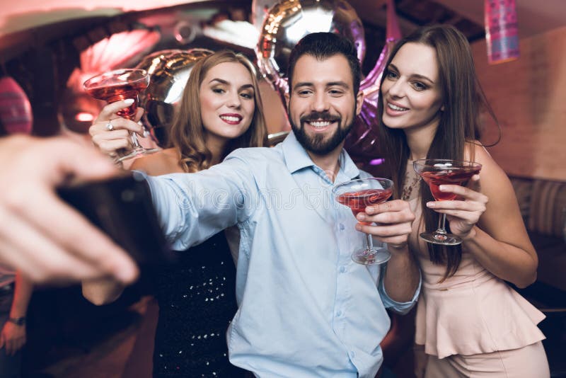 Ένα άτομο κάνει selfie με τους φίλους του Έχει τη διασκέδαση σε ένα νυχτερινό κέντρο διασκέδασης Ενάντια στη στάση υποβάθρου οι φ στοκ εικόνα με δικαίωμα ελεύθερης χρήσης Ένα άτομο κάνει selfie με τους φίλους του Έχει τη διασκέδαση σε ένα νυχτερινό κέντρο διασκέδασης Ενάντια στη στάση υποβάθρου οι φ στοκ εικόνα με δικαίωμα ελεύθερης χρήσης