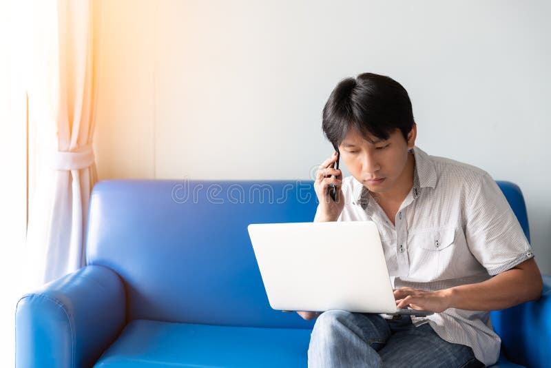 Ένα άτομο που χρησιμοποιεί το lap-top για τις εργασίες και τις σε απευθείας σύνδεση δραστηριότητες μιλώντας στο κινητό τηλέφωνο κ στοκ φωτογραφία με δικαίωμα ελεύθερης χρήσης Ένα άτομο που χρησιμοποιεί το lap-top για τις εργασίες και τις σε απευθείας σύνδεση δραστηριότητες μιλώντας στο κινητό τηλέφωνο κ στοκ φωτογραφία με δικαίωμα ελεύθερης χρήσης
