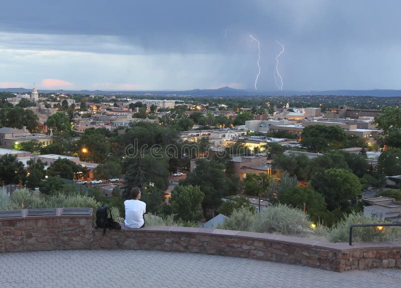 SANTA FE, NEW MEXICO, JULY 6. Fort Marcy Park on July 6, 2017, in Santa Fe, New Mexico. A Man Watches a Lightning Storm from Fort Marcy Park in Santa Fe. SANTA FE, NEW MEXICO, JULY 6. Fort Marcy Park on July 6, 2017, in Santa Fe, New Mexico. A Man Watches a Lightning Storm from Fort Marcy Park in Santa Fe.