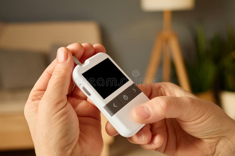 Ένα άτομο χειρίζεται μια κομψή συσκευή παρακολούθησης της υγείας εστιάζοντας στην οθόνη του ενώ κάθεται σε ένα άνετο σαλόνι γεμάτο στοκ εικόνα με δικαίωμα ελεύθερης χρήσης