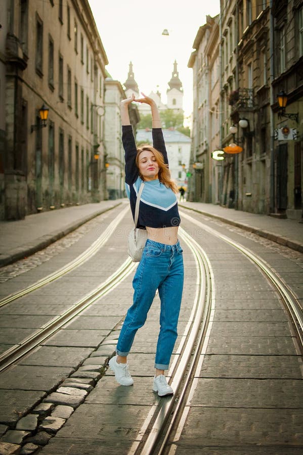 Ένα εκπληκτικό νεαρό κορίτσι απολαμβάνει το ταξίδι της νωρίς το πρωί στην άδεια πόλη της Ευρώπης στο δρόμο με τραμ στοκ εικόνα με δικαίωμα ελεύθερης χρήσης Ένα εκπληκτικό νεαρό κορίτσι απολαμβάνει το ταξίδι της νωρίς το πρωί στην άδεια πόλη της Ευρώπης στο δρόμο με τραμ στοκ εικόνα με δικαίωμα ελεύθερης χρήσης