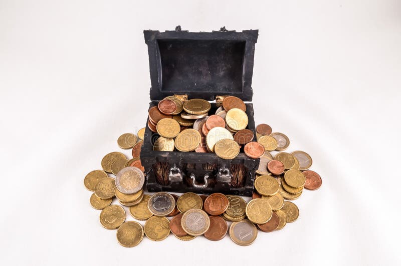 A treasure chest full of coins is on a white background. The coins are of different sizes and colors, including gold, silver, and bronze. Concept of wealth and abundance, real image. A treasure chest full of coins is on a white background. The coins are of different sizes and colors, including gold, silver, and bronze. Concept of wealth and abundance, real image