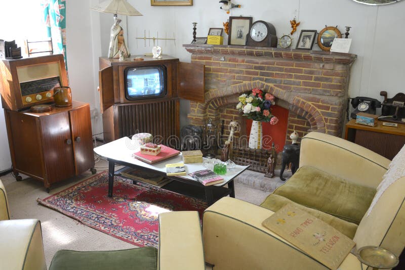 A 1940s 1950s living room with vintage furniture, coffee table, stone fireplace, vintage radio, cathode ray tube television and other items commonly found in houses of that era. A 1940s 1950s living room with vintage furniture, coffee table, stone fireplace, vintage radio, cathode ray tube television and other items commonly found in houses of that era.