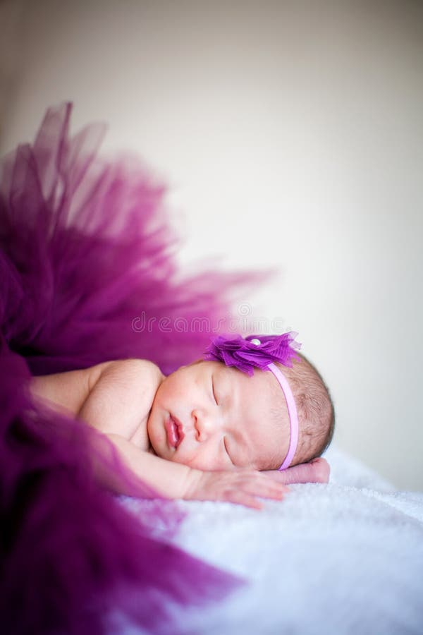 A sleeping baby girl wearing purple yarn soft focus. A sleeping baby girl wearing purple yarn soft focus