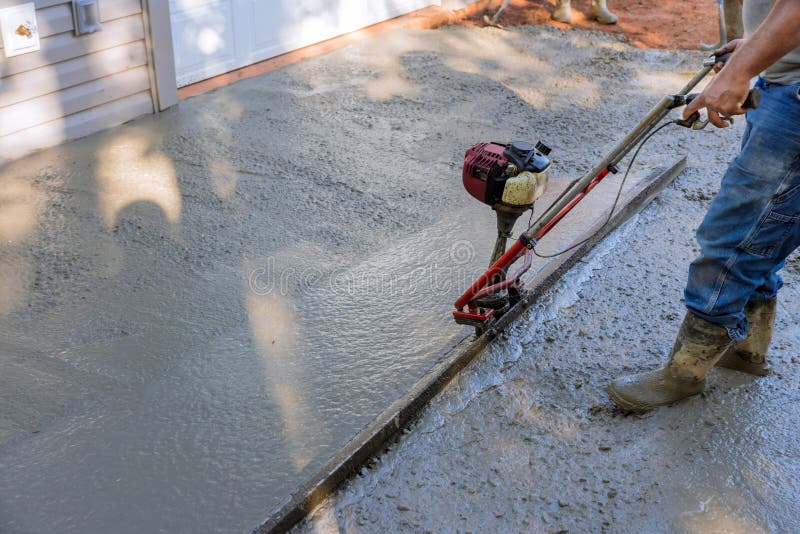An alignment machine is used to align new fundation compacted layer of fresh concrete on new driveways constructed. An alignment machine is used to align new fundation compacted layer of fresh concrete on new driveways constructed.