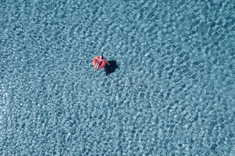 ένα παιδί κολυμπά σε κόκκινο φουσκωτό κύκλο. η έννοια των αργιών και της χαλάρωσης. κεραία. στοκ εικόνες με δικαίωμα ελεύθερης χρήσης