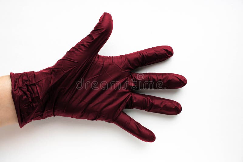ένα χέρι σε ένα χειρουργικό χρώμα γάντι viva magenta που επισημαίνεται σε λευκό φόντο. παραγωγή καουτσούκ στοκ εικόνες