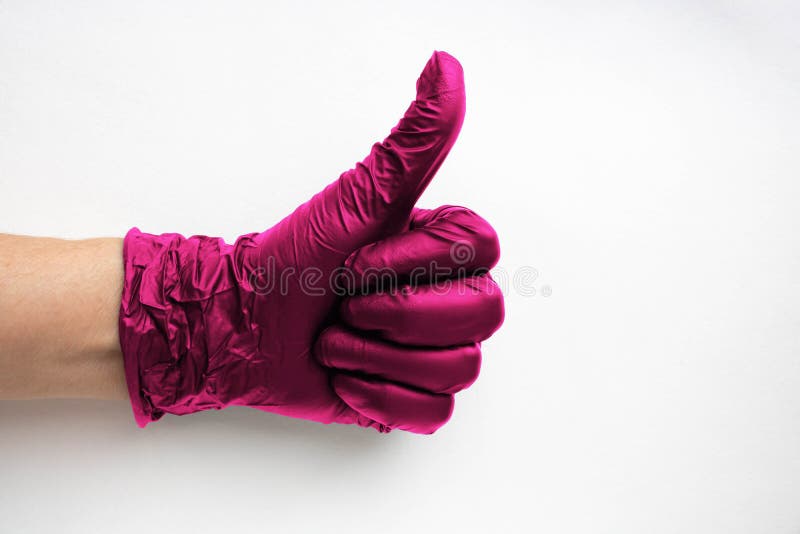 ένα χέρι σε ένα χειρουργικό χρώμα γάντι viva magenta που επισημαίνεται σε λευκό φόντο. παραγωγή καουτσούκ στοκ φωτογραφία