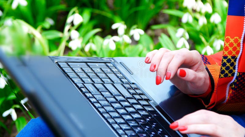 Ένα όμορφο νέο κορίτσι εργάζεται με ένα lap-top στη μέση ενός δασικού συνόλου άνοιξη της άνθησης snowdrops φιλμ μικρού μήκους Ένα όμορφο νέο κορίτσι εργάζεται με ένα lap-top στη μέση ενός δασικού συνόλου άνοιξη της άνθησης snowdrops φιλμ μικρού μήκους