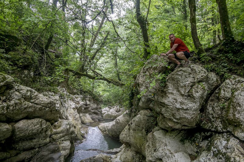 ένας άνδρας ταξιδιώτης θαυμάζει το φαράγγι του ποταμού αγκούρα στο σότσι στοκ φωτογραφία