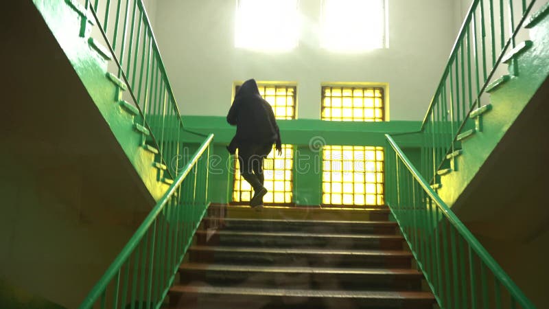 ένας άντρας με κουκούλα στο κεφάλι του ανεβαίνει τις σκάλες στο σχολικό κολέγιο