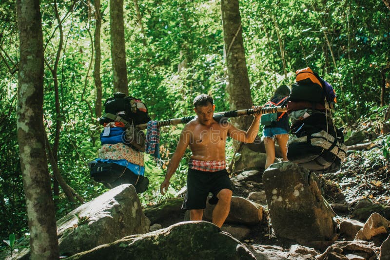 A porter who is a villager who is hired to carry things up Phu Kradueng is climbing on a rock that is on the mountain path at Phu Kradueng, Loei Province, Thailand, December 31, 2017. A porter who is a villager who is hired to carry things up Phu Kradueng is climbing on a rock that is on the mountain path at Phu Kradueng, Loei Province, Thailand, December 31, 2017.