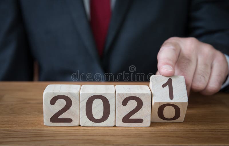 A close up of a businessman looking ahead to the future with confidence and changing the date of a calendar to 2021. A close up of a businessman looking ahead to the future with confidence and changing the date of a calendar to 2021