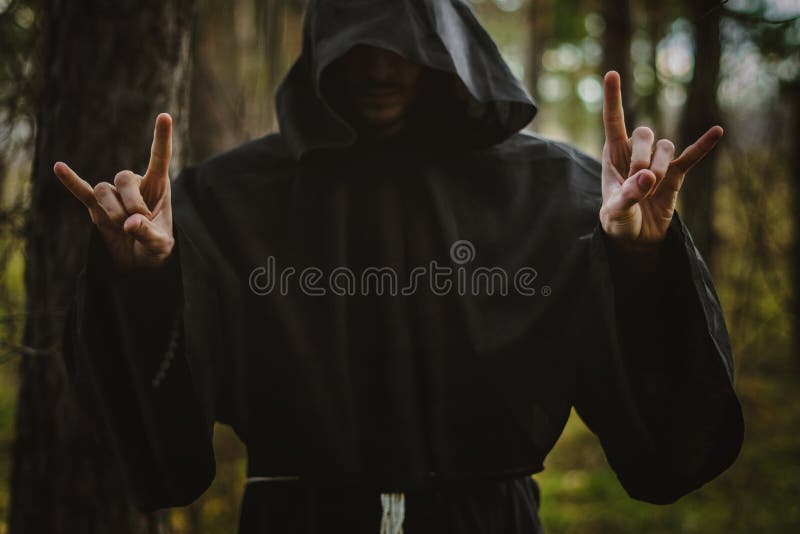 A creepy man in a black hood in the forest. A creepy man in a black hood in the forest