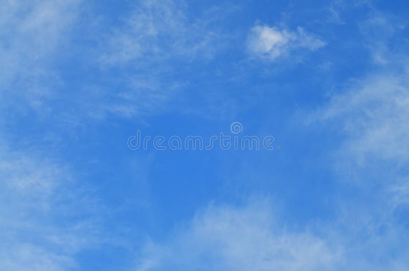 A blue cloudy sky with many small clouds blocking the sun. A blue cloudy sky with many small clouds blocking the sun