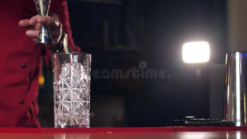 ένας πραγματικός επαγγελματίας μπάρμαν που δημιουργεί ένα κοκτέιλ. πεπειραμένος μπάρμαν που χώνει ένα αλκοολούχο ποτό στο ποτήρι π