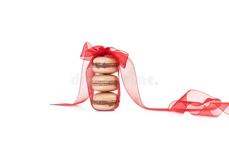 Ένας σωρός τριών macarons με έναν κόκκινο δεσμό τόξων στοκ φωτογραφίες Ένας σωρός τριών macarons με έναν κόκκινο δεσμό τόξων στοκ φωτογραφίες