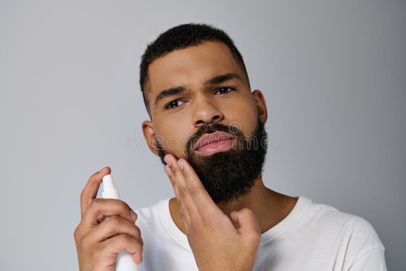 A handsome young man with a beard applying some locion, stock photo. A handsome young man with a beard applying some locion, stock photo