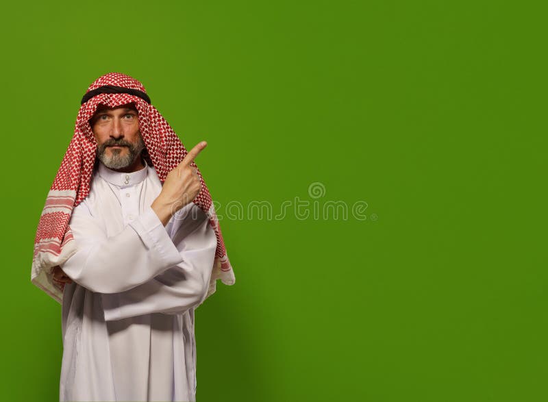 mature Muslim man in traditional dishdasha points his finger towards copy space symbolizing concept of Sharia law, Islamic legal system based on teachings of Quran and Hadith. authority, leadership, and principles of justice and ethics within the legal framework of Sharia law, with copy space for additional text or design elements. High quality photo. mature Muslim man in traditional dishdasha points his finger towards copy space symbolizing concept of Sharia law, Islamic legal system based on teachings of Quran and Hadith. authority, leadership, and principles of justice and ethics within the legal framework of Sharia law, with copy space for additional text or design elements. High quality photo