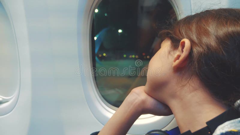 Έννοια αεροσκαφών αεροπορίας κοριτσιών εφήβων το νέο κορίτσι φαίνεται έξω η συνεδρίαση αεροπλάνων από τον τρόπο ζωής παραθύρων πτ