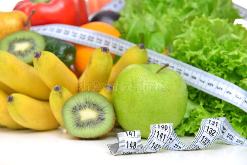 Diet weight loss breakfast concept with tape measure organic green apple salad bananas kiwi avocado grapefruit red pepper pear on a white background. Diet weight loss breakfast concept with tape measure organic green apple salad bananas kiwi avocado grapefruit red pepper pear on a white background