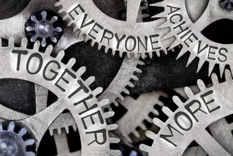 Macro photo of tooth wheel mechanism with TOGETHER EVERYONE ACHIEVES MORE words imprinted on metal surface; TEAM concept. Macro photo of tooth wheel mechanism with TOGETHER EVERYONE ACHIEVES MORE words imprinted on metal surface; TEAM concept