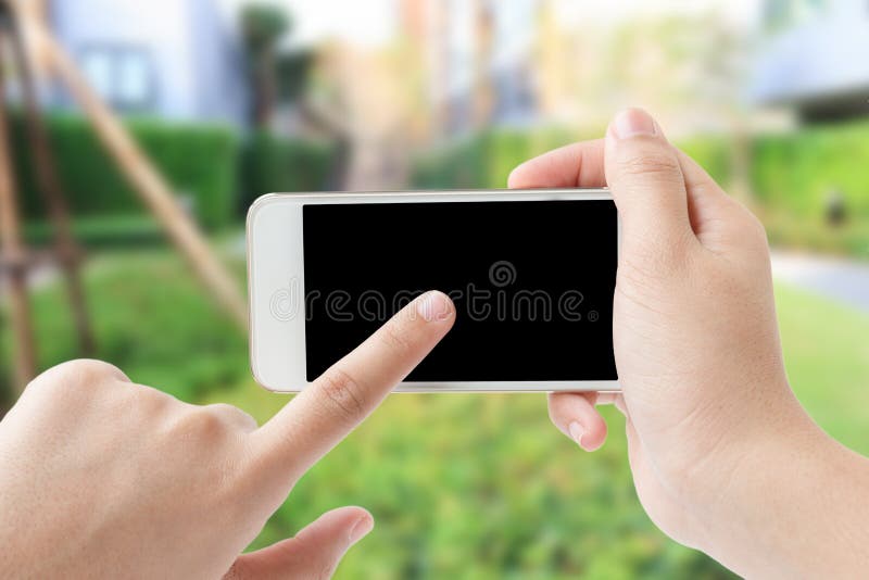Έννοια του χεριού γυναικών σχετικά με το smartphone στον κήπο στοκ φωτογραφία με δικαίωμα ελεύθερης χρήσης Έννοια του χεριού γυναικών σχετικά με το smartphone στον κήπο στοκ φωτογραφία με δικαίωμα ελεύθερης χρήσης