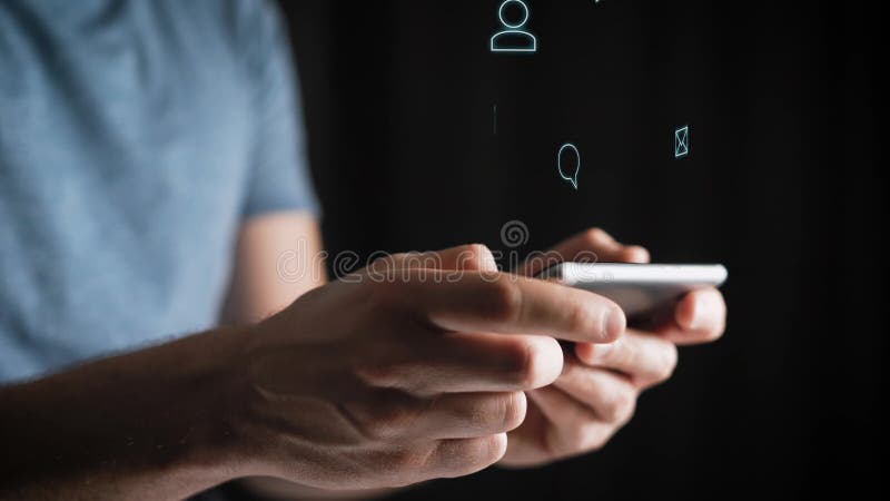 Έννοια, ψηφιακή σε απευθείας σύνδεση ζωή και κοινωνικά δίκτυα Ένας νεαρός άνδρας σε μια μπλε μπλούζα χρησιμοποιεί το smartphone τ