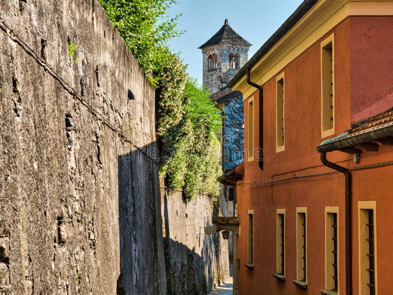 Έρημοι τοίχοι οδών με μέσω και πετρών στο SAN Giulio Island στη λίμνη Orta Ιταλία με το καμπαναριό του SAN Giulio Basilica στοκ φωτογραφία με δικαίωμα ελεύθερης χρήσης Έρημοι τοίχοι οδών με μέσω και πετρών στο SAN Giulio Island στη λίμνη Orta Ιταλία με το καμπαναριό του SAN Giulio Basilica στοκ φωτογραφία με δικαίωμα ελεύθερης χρήσης
