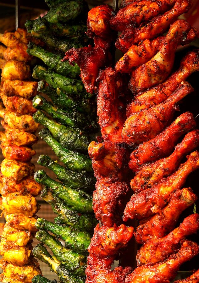 Ready to cook masala soaked chicken leg pieces piled and hanging in a shop during the muslim festive season of ramzaan or ramadan. Ready to cook masala soaked chicken leg pieces piled and hanging in a shop during the muslim festive season of ramzaan or ramadan