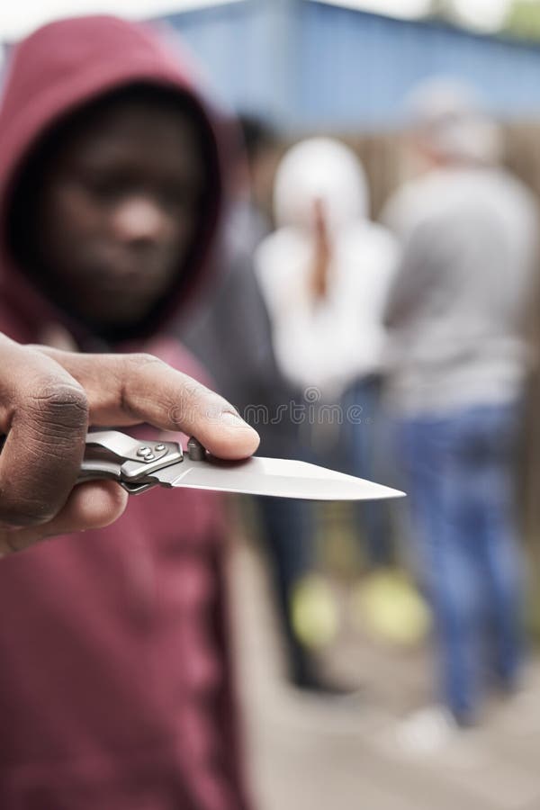 Έφηβος στην αστική συμμορία που δείχνει το μαχαίρι προς τη κάμερα στοκ φωτογραφία με δικαίωμα ελεύθερης χρήσης Έφηβος στην αστική συμμορία που δείχνει το μαχαίρι προς τη κάμερα στοκ φωτογραφία με δικαίωμα ελεύθερης χρήσης