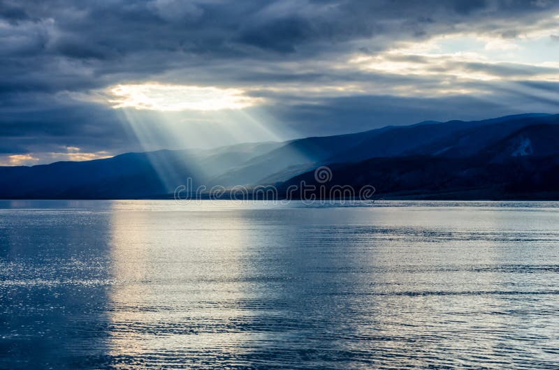 Sun shining through thick cloudy sky, silver lining, lake Baikal. Sun shining through thick cloudy sky, silver lining, lake Baikal