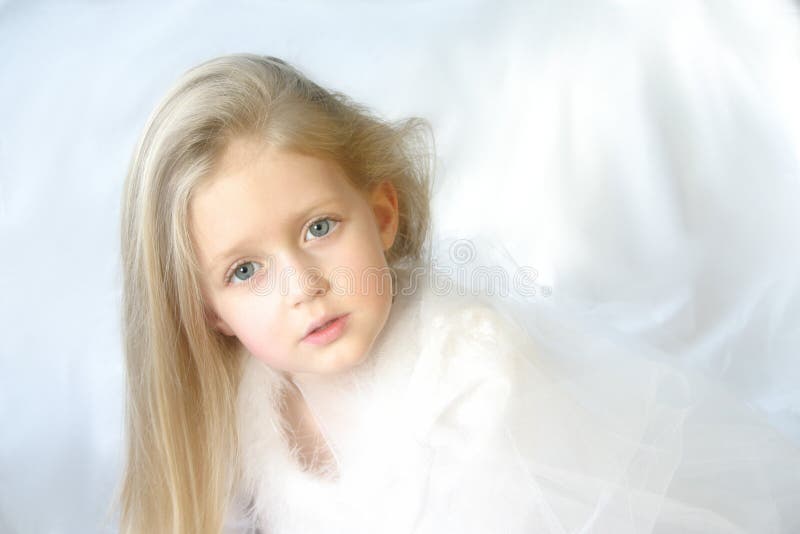 An angelic young blonde girl against a while background... a symbol of innocence, purity, peace, and angels. Great for religious holidays like Christmas. An angelic young blonde girl against a while background... a symbol of innocence, purity, peace, and angels. Great for religious holidays like Christmas.