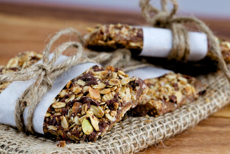 Αγροτικοί φραγμοί Granola που συσσωρεύονται και Burlap με το σπάγγο στοκ εικόνα με δικαίωμα ελεύθερης χρήσης Αγροτικοί φραγμοί Granola που συσσωρεύονται και Burlap με το σπάγγο στοκ εικόνα με δικαίωμα ελεύθερης χρήσης