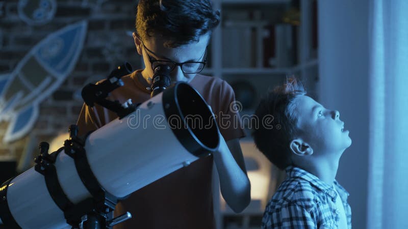 αγόρια στο δωμάτιό τους κοιτάζοντας τα αστέρια με ένα τηλεσκόπιο