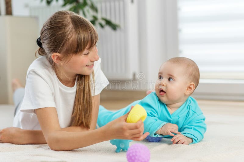 Αδελφή που εμπλέκει μικρό αδερφό με αισθητηριακό παιχνίδι στοκ φωτογραφία