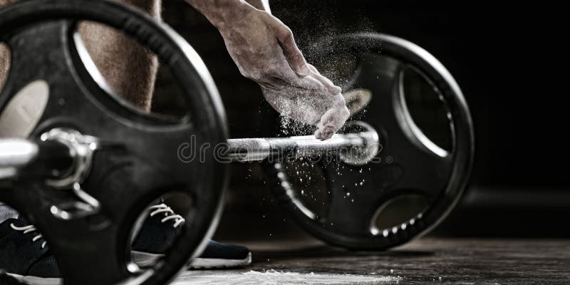 Sports background. Young athlete getting ready for weight lifting training. Powerlifter hand in talc preparing to bench press. Sports background. Young athlete getting ready for weight lifting training. Powerlifter hand in talc preparing to bench press