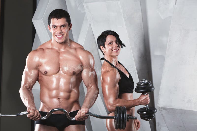 Αθλητικοί άνδρας και γυναίκα με ένα Dumbells στοκ φωτογραφία Αθλητικοί άνδρας και γυναίκα με ένα Dumbells στοκ φωτογραφία
