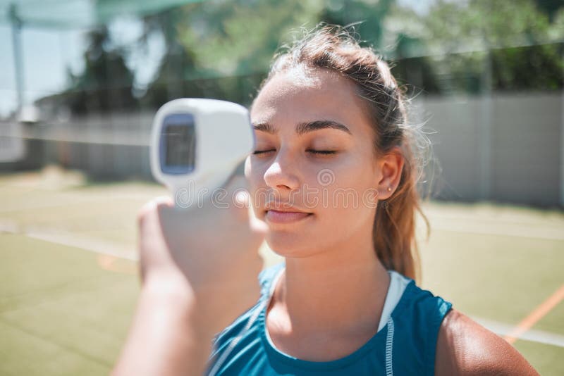 Ftiness, sports and thermometer of a women athlete before a match or game on the court. Temperature, safety health and wellness of a strong and active women before exercising in sport training. Ftiness, sports and thermometer of a women athlete before a match or game on the court. Temperature, safety health and wellness of a strong and active women before exercising in sport training